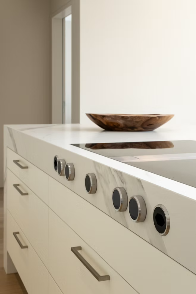Klassische cremefarbene Front mit Metallgriffen und mineralischer Arbeitsplatte
